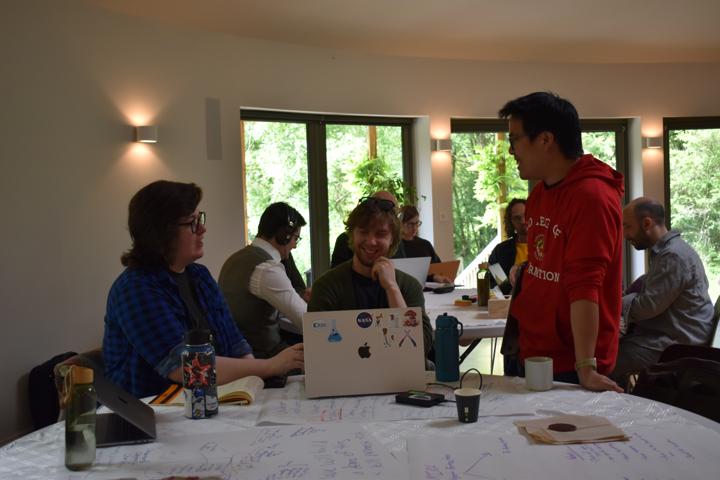 People working together around a table with laptops open.