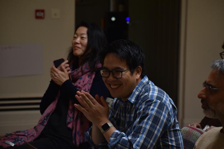 Three people seated in a row, laughing together.