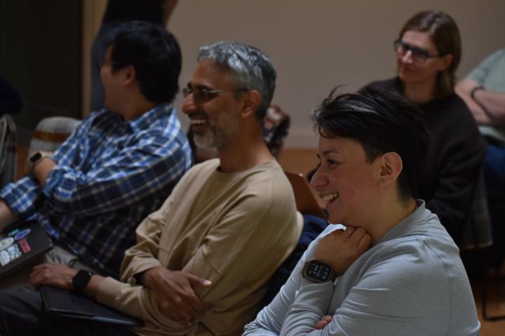 Three people seated together, laughing.